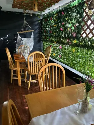 a dining room with a table and chairs and a green wall at Casa Raizal in Envigado