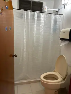 a bathroom with a toilet with a shower curtain at Casa Raizal in Envigado