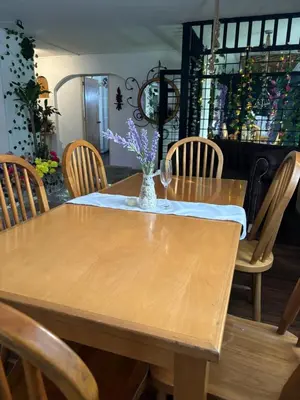 a wooden table with a vase of flowers on it at Casa Raizal in Envigado