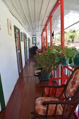 a hallway with chairs and potted plants on a porch at La posada de Martha in Marulanda
