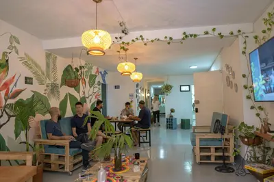 a group of people sitting in a room with plants at Laureles Garden Hostel in Medellín