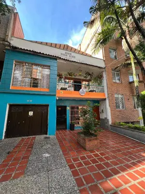 a blue building with a brick courtyard in front of it at Laureles Garden Hostel in Medellín