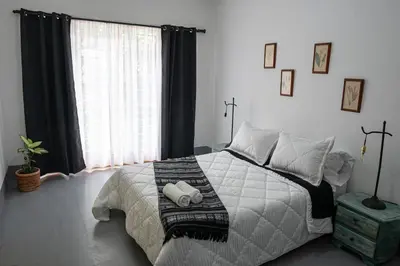 a bedroom with a bed and a large window at Laureles Garden Hostel in Medellín