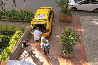 a group of people standing in front of a yellow bus at Laureles Garden Hostel in Medellín