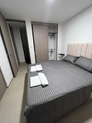 a bedroom with a large bed with towels on it at Mirador del Laureles, AC, Piscina, Parqueadero 701 in Medellín