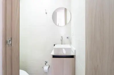 a white bathroom with a sink and a mirror at Balcón en Laureles, AC, Piscina, Estacionamiento 601 in Medellín