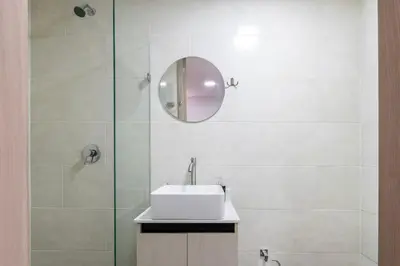 a white bathroom with a sink and a mirror at Balcón en Laureles, AC, Piscina, Estacionamiento 601 in Medellín