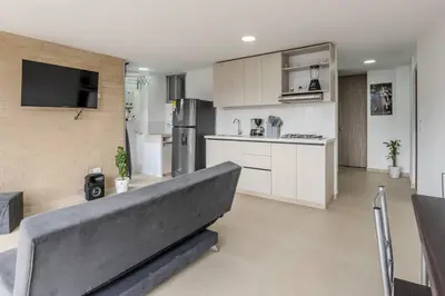 a living room with a couch and a kitchen at Balcón en Laureles, AC, Piscina, Estacionamiento 601 in Medellín