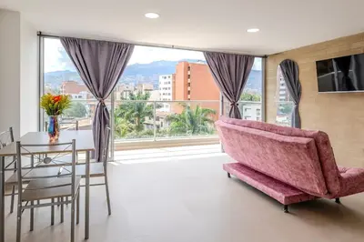 a living room with a pink couch and a table at Lindo apartamento en Laureles con piscina 501 in Medellín