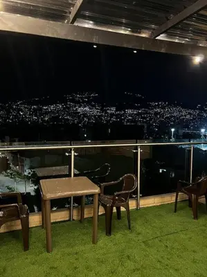 a table and chairs on a balcony with a view of a city at Lindo apartamento en Laureles con piscina 501 in Medellín