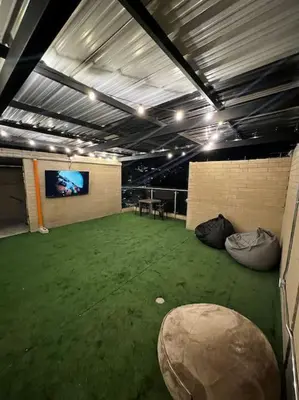 a large room with a large green floor with a tv at Lindo apartamento en Laureles con piscina 501 in Medellín