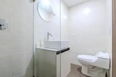 a white bathroom with a sink and a toilet at Apartamento centrico en Laureles con piscina 301 in Medellín