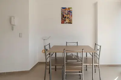 a dining room table with chairs and a picture on the wall at Apartamento centrico en Laureles con piscina 301 in Medellín