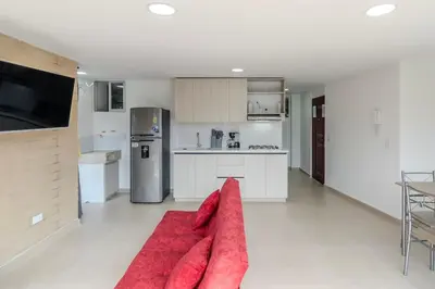 a living room with a red couch in a kitchen at Apartamento centrico en Laureles con piscina 301 in Medellín