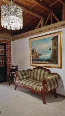 a couch in a room with a painting and a chandelier at Casa Amaru in Guarne