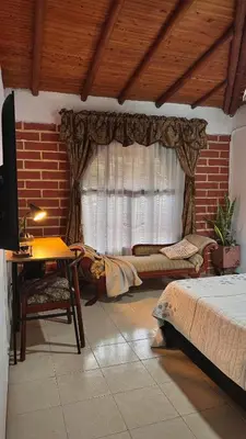 a bedroom with a bed and a table and a window at Casa Amaru in Guarne