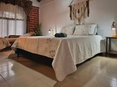 a bedroom with a bed with a white comforter at Casa Amaru in Guarne