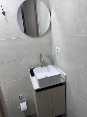 a bathroom with a white sink and a mirror at Espacioso apartamento con piscina en Laureles 201 in Medellín