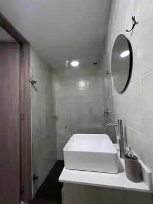 a white bathroom with a sink and a mirror at Espacioso apartamento con piscina en Laureles 201 in Medellín