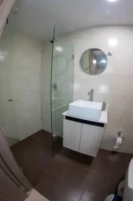 a bathroom with a sink and a glass shower at Espacioso apartamento con piscina en Laureles 201 in Medellín