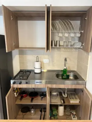 a small kitchen with a sink and a stove at Apartaestudio moderno cerca al cable in Manizales
