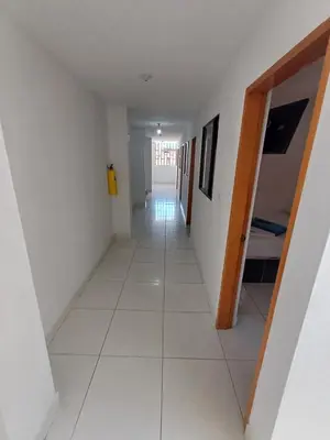 a long hallway with a white floor and a room at Hotel El Mirador in San Carlos