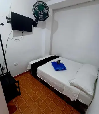 a room with a bed with a fan on the wall at Hotel El Mirador in San Carlos