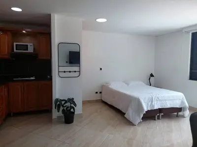 a bedroom with a bed and a tv on the wall at Apto tipo Loft en Laureles Nutibara Increíble Vista in Medellín