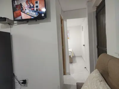 a living room with a television on a wall at Apartaestudio la 70, estadio in Medellín