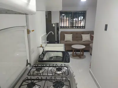 a kitchen with a stove and a couch at Apartaestudio la 70, estadio in Medellín