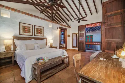a bedroom with a bed and a table in a room at Casa Linaje Hotel Boutique -Cauca Viejo- Mayores de 10 años in Jericó