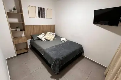 a bedroom with a bed and a flat screen tv at Elegante apto Laureles Estadio in Medellín