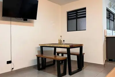 a table and bench in a room with a tv at Elegante apto Laureles Estadio in Medellín
