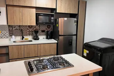 a kitchen with a stove and a refrigerator at Elegante apto Laureles Estadio in Medellín