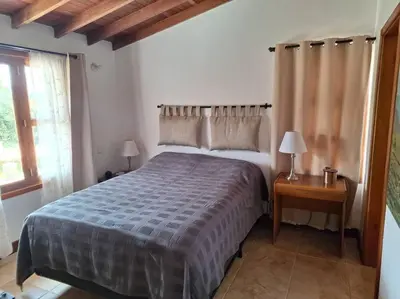 a bedroom with a bed and a table with two lamps at Casa San Miguel Santa Elena in Medellín