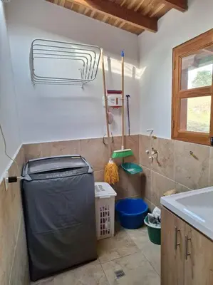a bathroom with a trash can and a sink at Casa San Miguel Santa Elena in Medellín