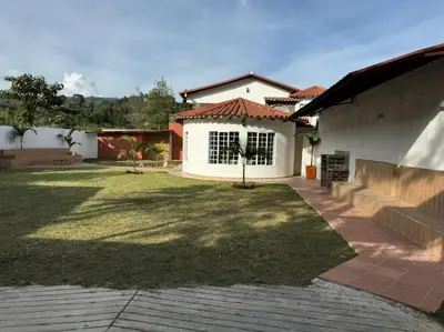 a backyard of a house with a grass yard at Hermosa cabaña en Guarne in Copacabana