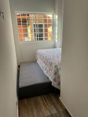 a small bedroom with a bed and a window at Hermosa cabaña en Guarne in Copacabana