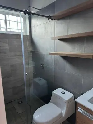 a bathroom with a toilet and a glass shower at Hermosa cabaña en Guarne in Copacabana