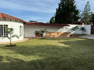 a house with palm trees in the yard at Hermosa cabaña en Guarne in Copacabana