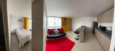 a living room with a black ottoman and a red rug at Edificio Urban Frente universidad Autónoma in Manizales