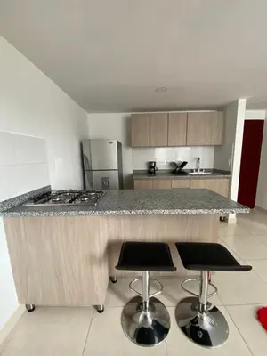 a kitchen with a counter and two bar stools at Edificio Urban Frente universidad Autónoma in Manizales