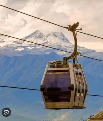 a ski lift with a snow covered mountain in the background at Edificio Urban Frente universidad Autónoma in Manizales