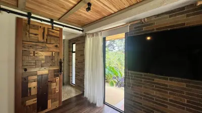 a living room with a tv and a brick wall at Autenthico Sajonia Hotel Aeropuerto in Rionegro