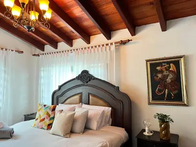 a bedroom with a large bed with a painting on the wall at Autenthico Sajonia Hotel Aeropuerto in Rionegro