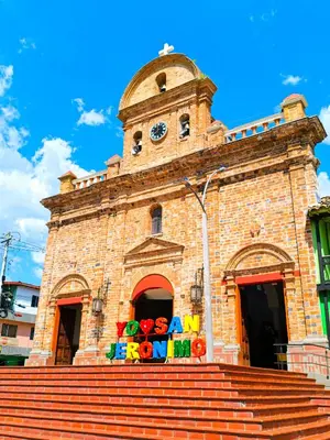 a large brick building with a clock tower at Casa Premium Las Palmas San Jeronimo in San Jerónimo