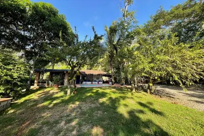 a house with a yard with trees in front of it at Paraiso del Cauca in Jericó