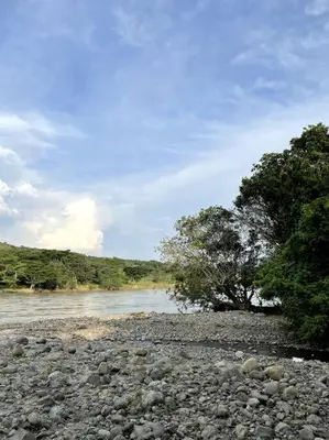 a river with rocks and trees in the background at Paraiso del Cauca in Jericó