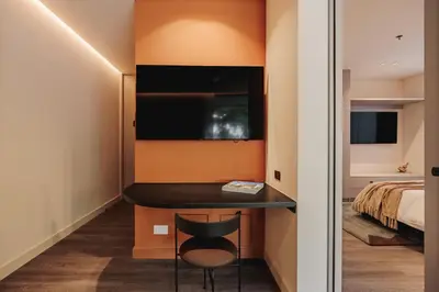 a small room with a desk and a bed at Nock - Reserved Residences in Medellín