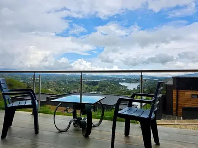 a table and two chairs on a balcony with a view at Montecielo Lodge 41 - Jacuzzi y Vista Piedra Peñol in El Peñol
